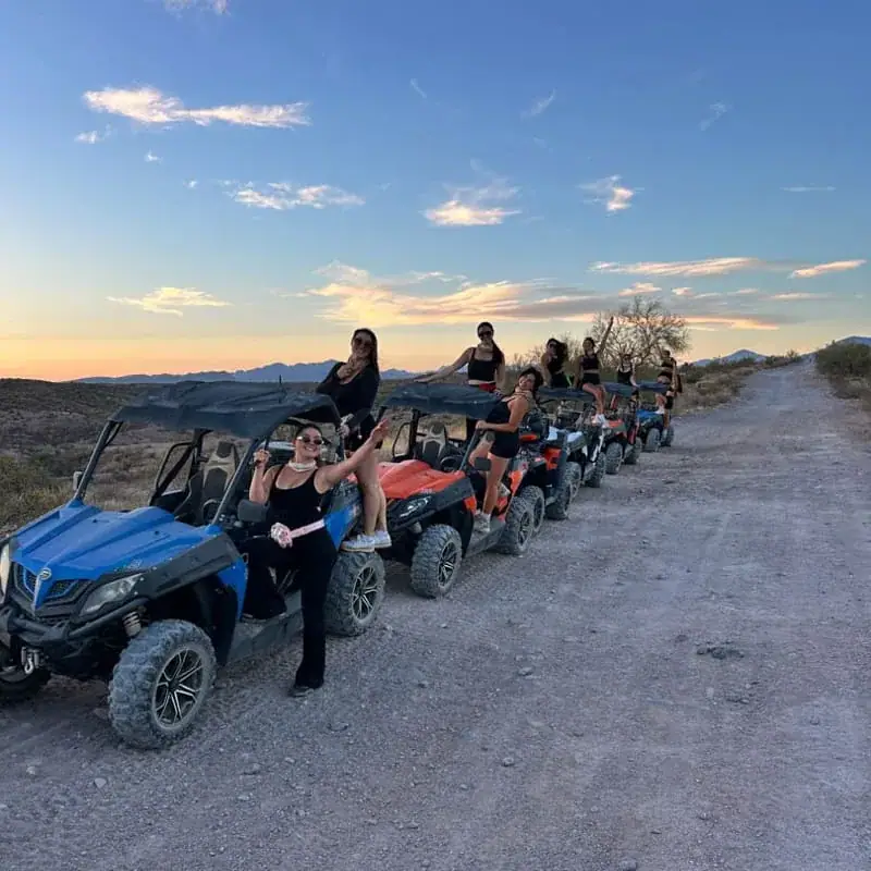 Group posing on sand buggies at sunset near Phoenix
