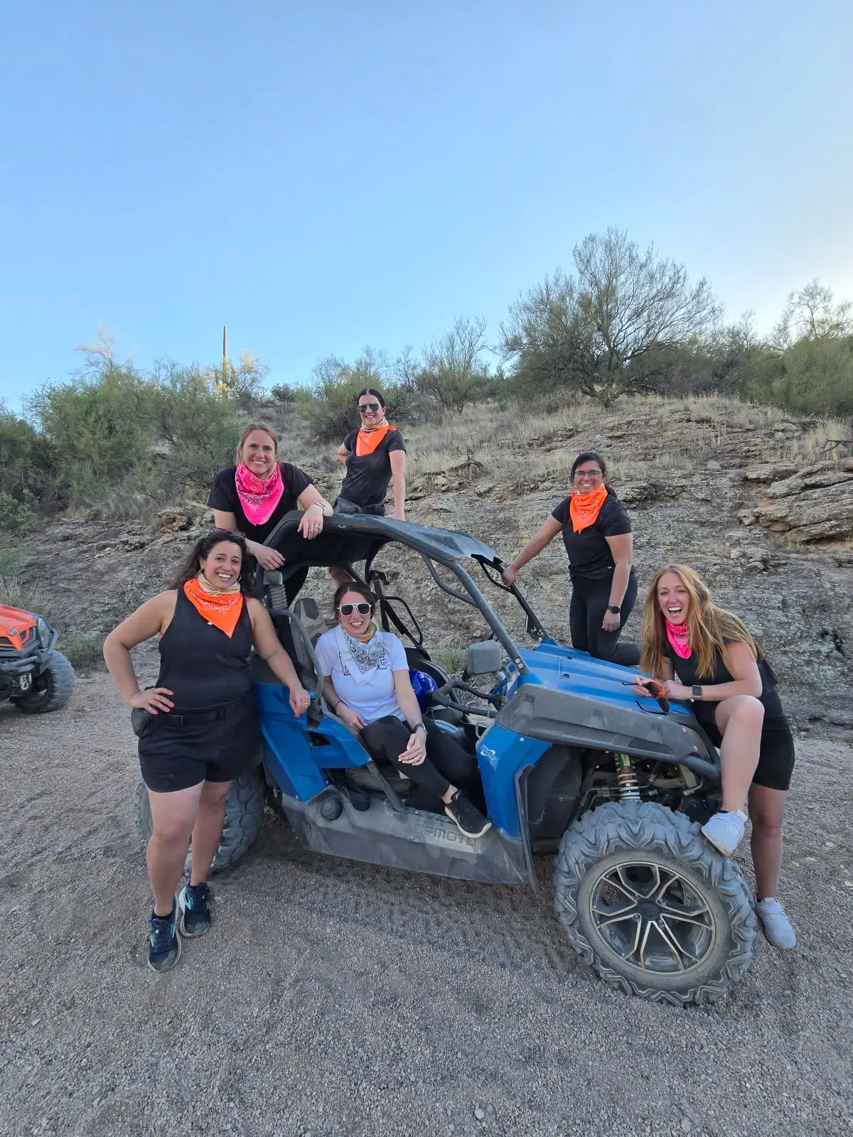 A bachelorette group in bandanas by a blue sand buggy