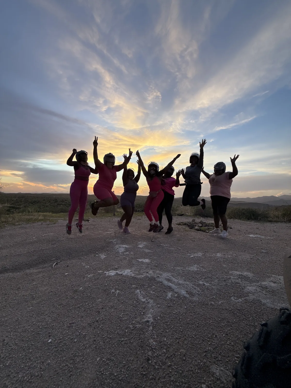Bachelorette party jumping in silhouette against a Sonoran Desert sunset near Scottsdale