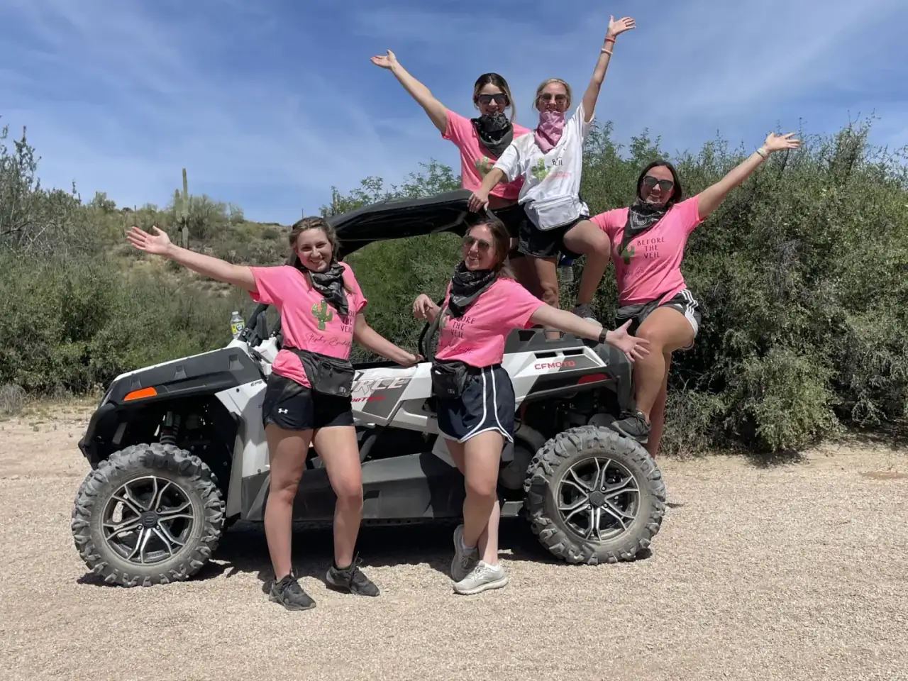 Bachelorette party in pink shirts celebrating on an ATV