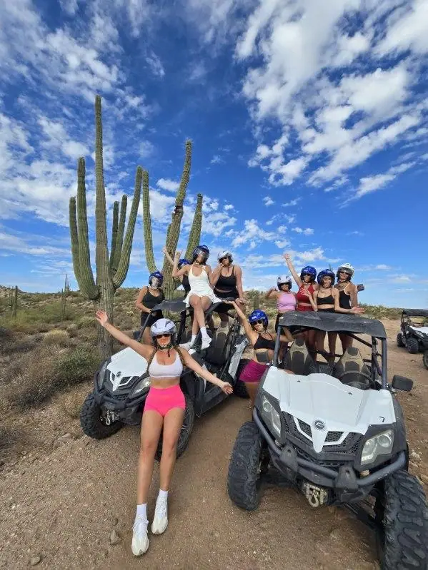 A bachelorette in pink by a sand buggy and saguaro