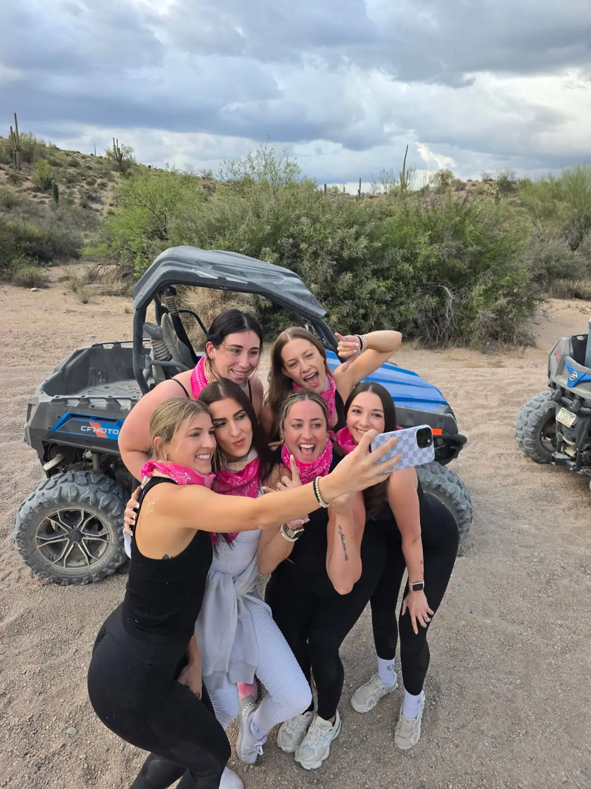 A bachelorette group selfie by a blue sand buggy