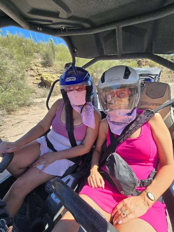 Bachelorette riders in pink inside their sand buggy