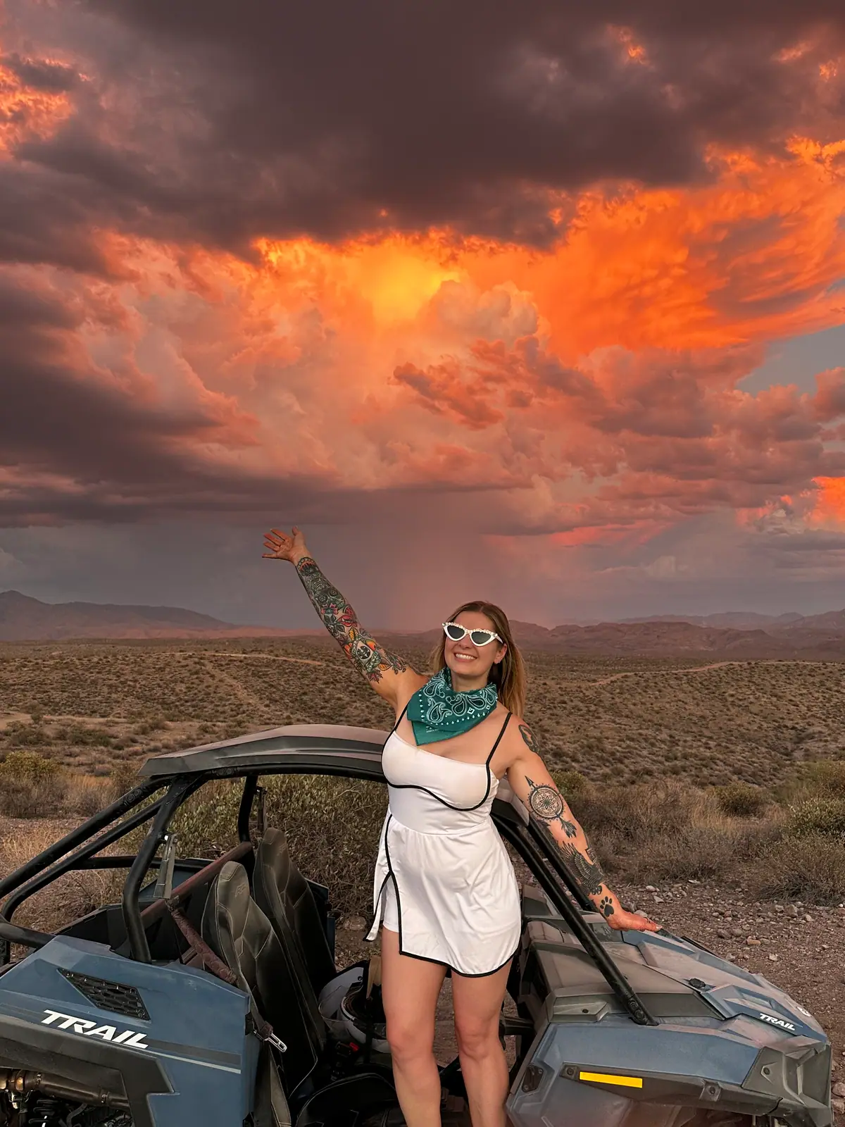 A bride in white by a Polaris buggy at a fiery Scottsdale sunset