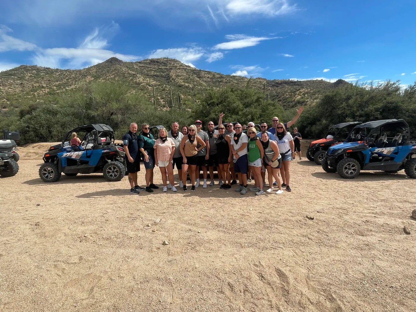 A large corporate group with blue sand buggies and mountains on a Scottsdale desert tour
