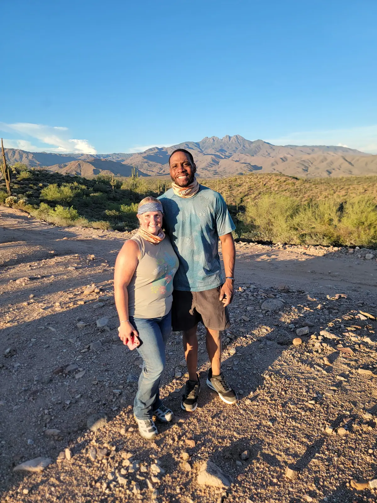 A couple at golden hour with the Four Peaks mountains behind them on a Scottsdale desert tour