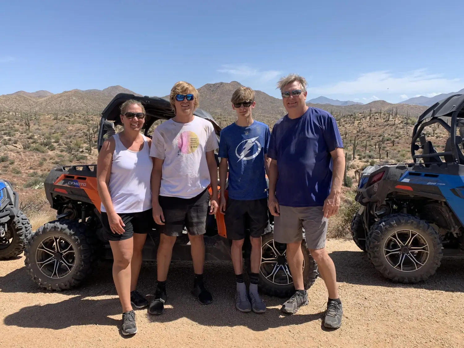 Family posing next to off-road vehicles in the Sonoran Desert