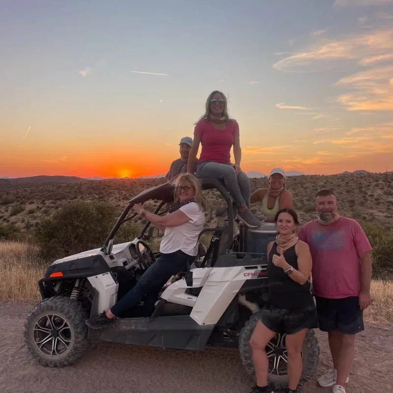 Friends posing on an ATV during a sunset tour near Phoenix