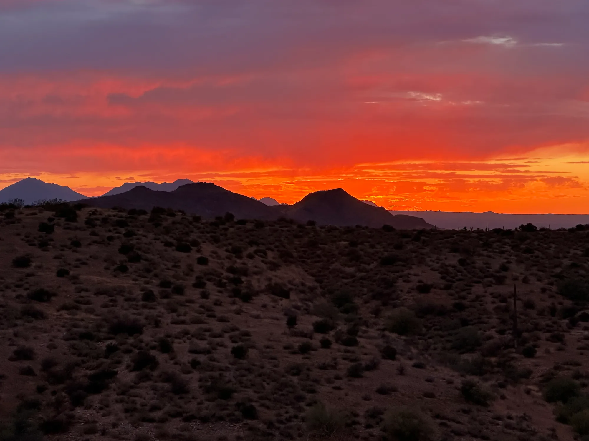 A dramatic fiery orange sunset over the Sonoran Desert mountains near Scottsdale