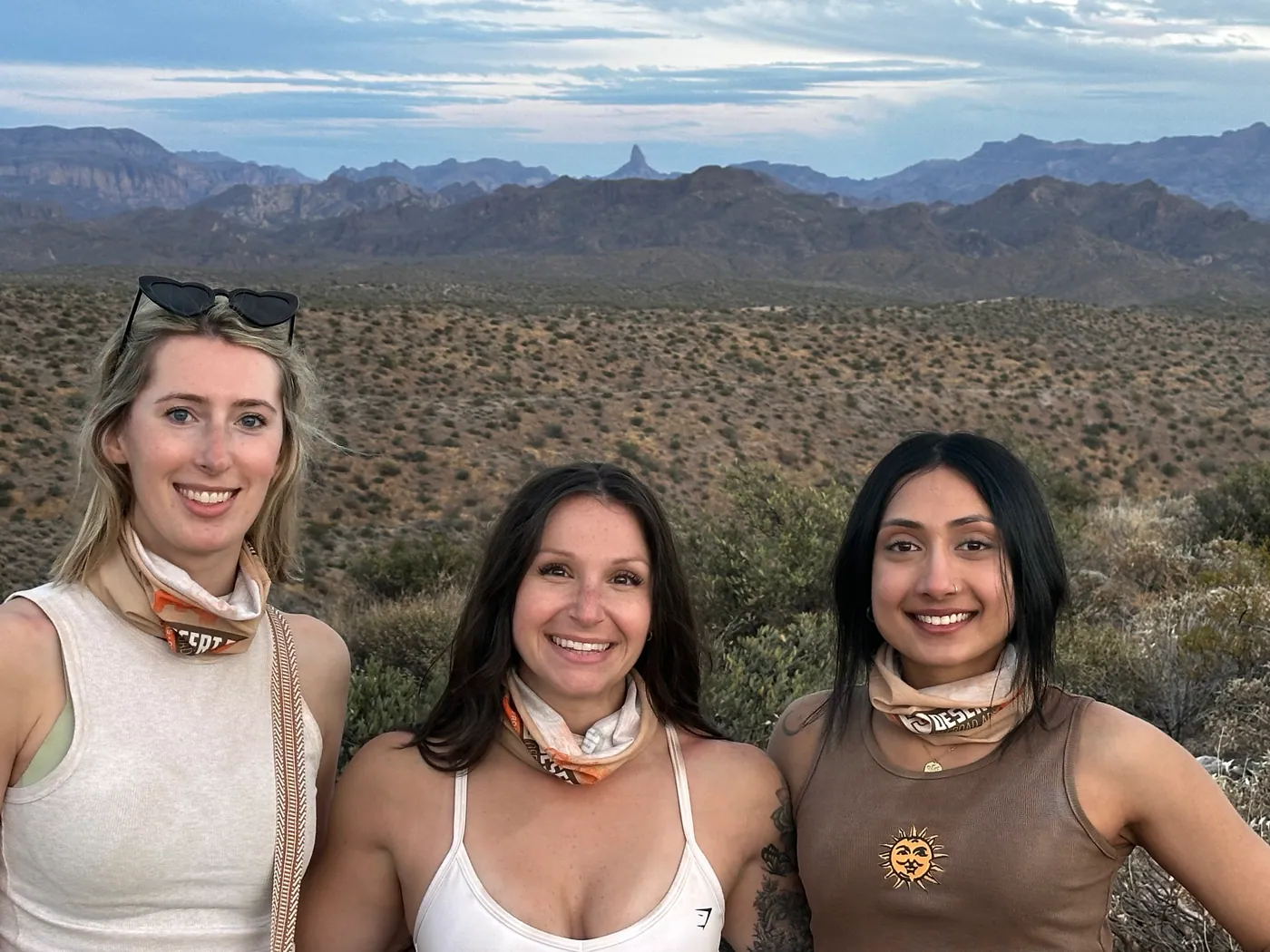 Friends at golden hour with Weavers Needle behind them on a Scottsdale desert tour