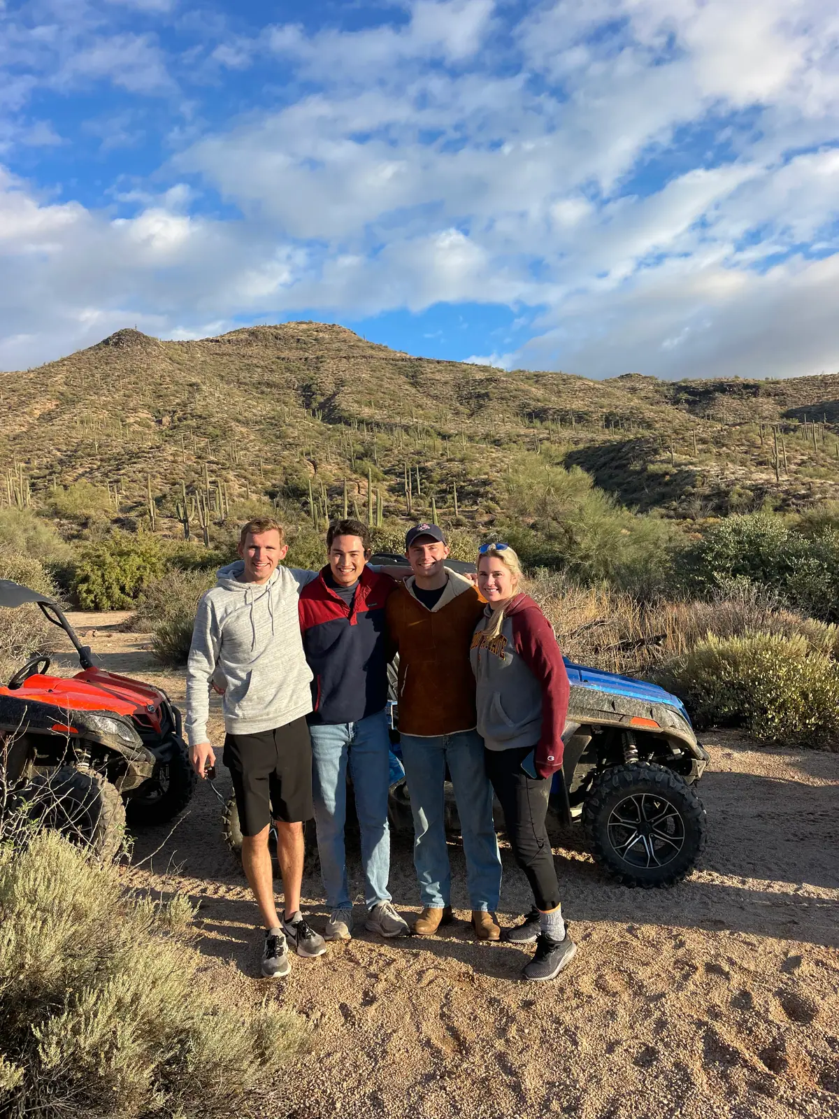A group of friends with their buggies and mountains behind