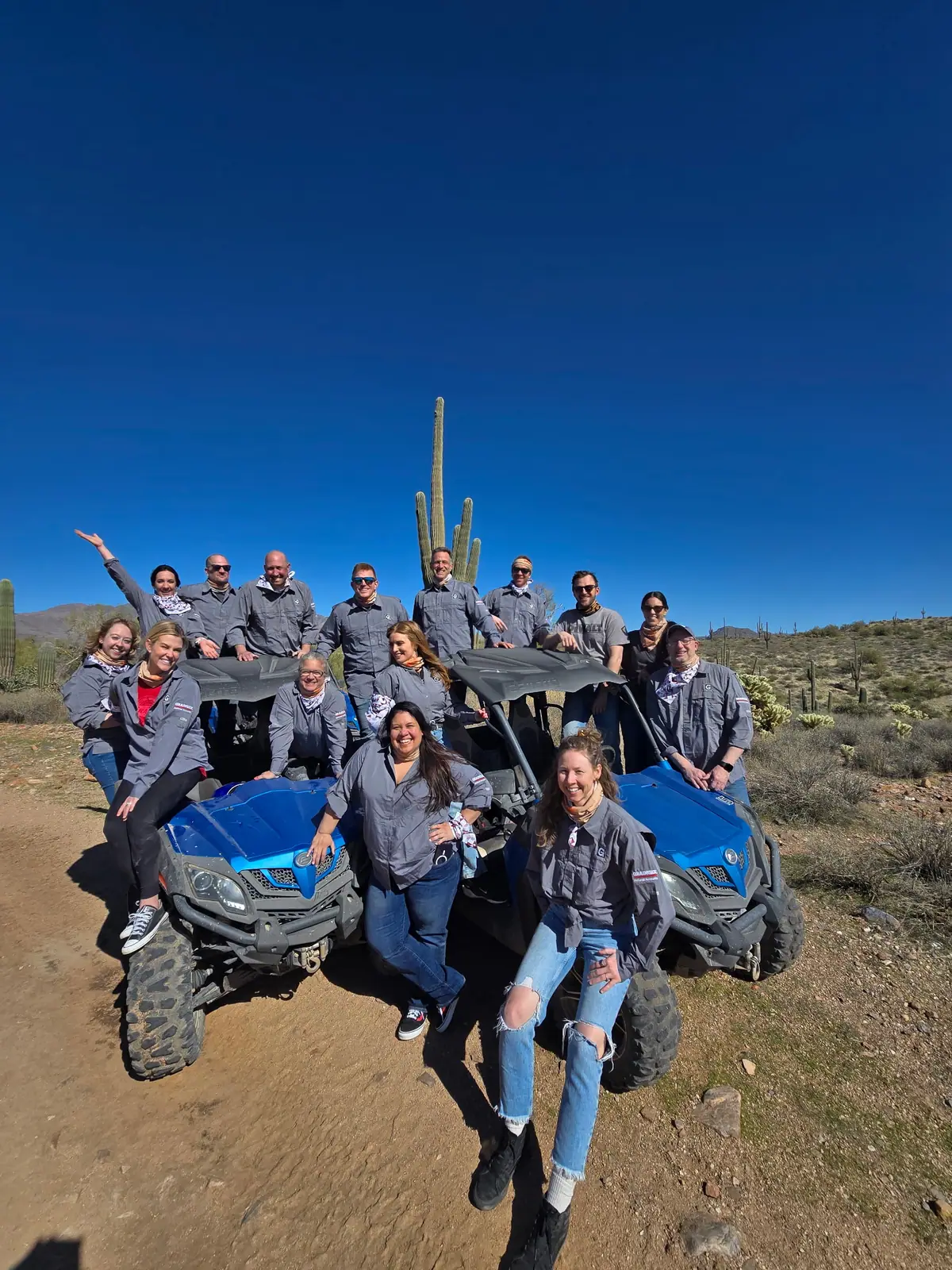 A group celebrating on a blue sand buggy in the Scottsdale desert