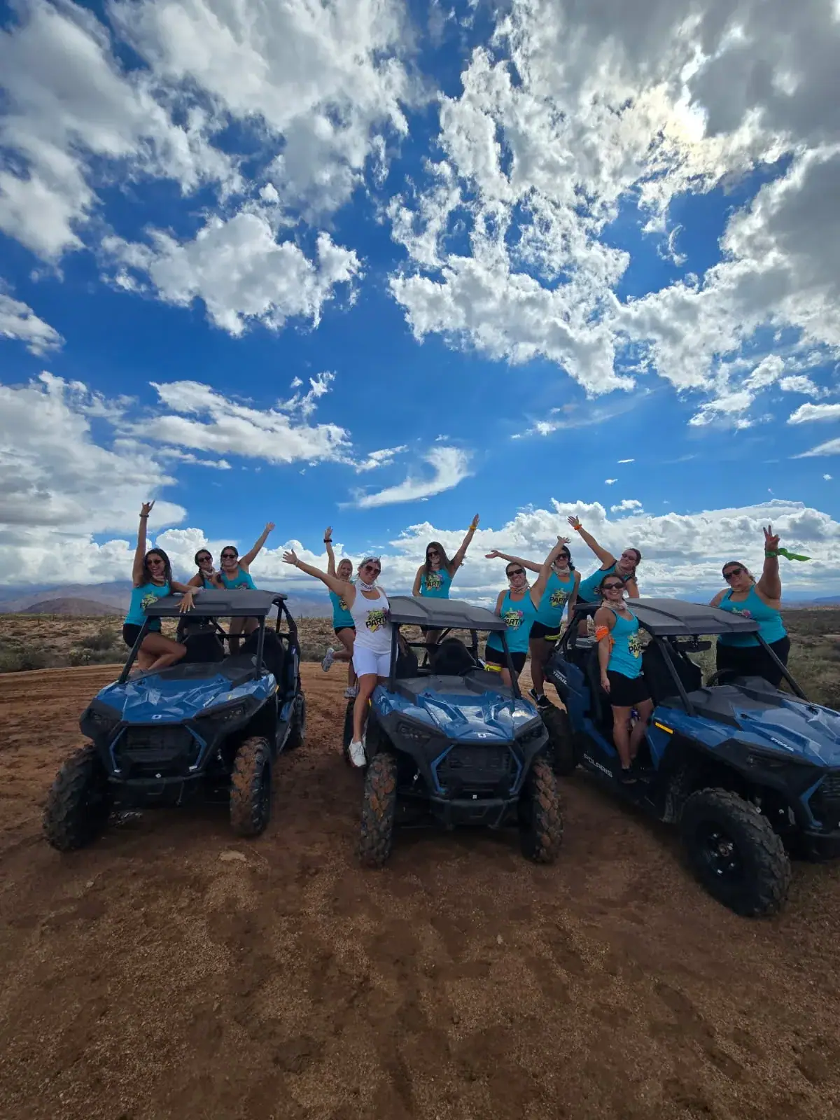 A team celebrating with their UTVs in the Sonoran Desert