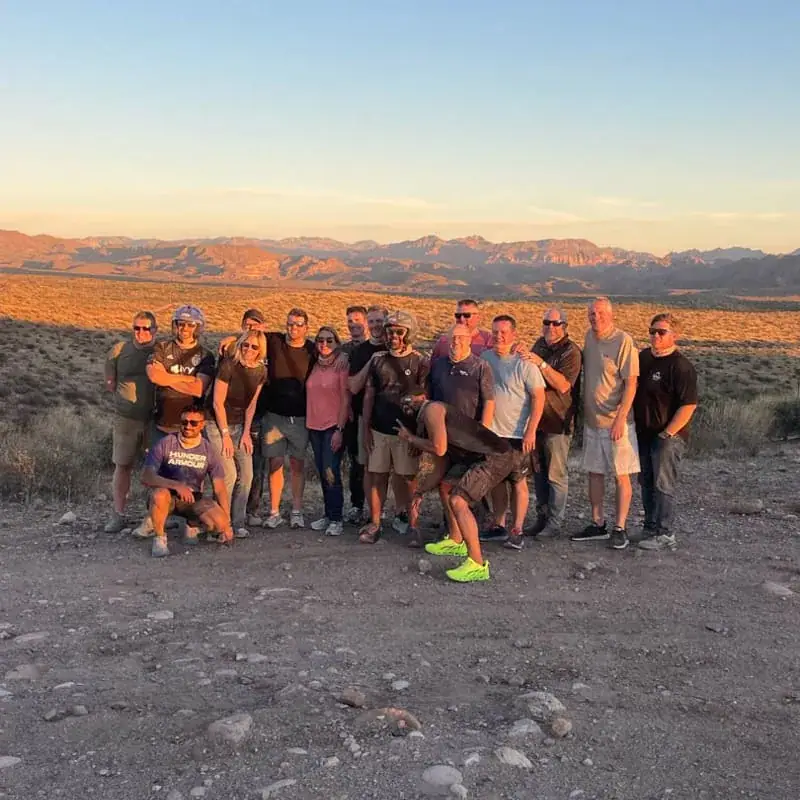 Group of adventurers posing together at sunset