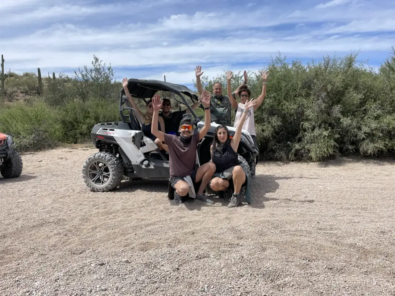 Friends with hands up in the desert
